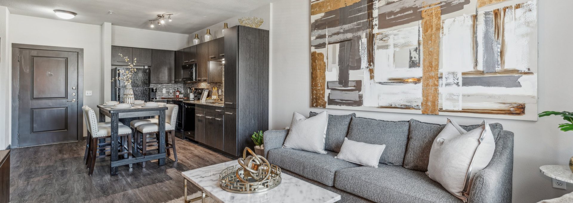 the living room has a gray couch and a gray coffee table at The Terra at University North Park